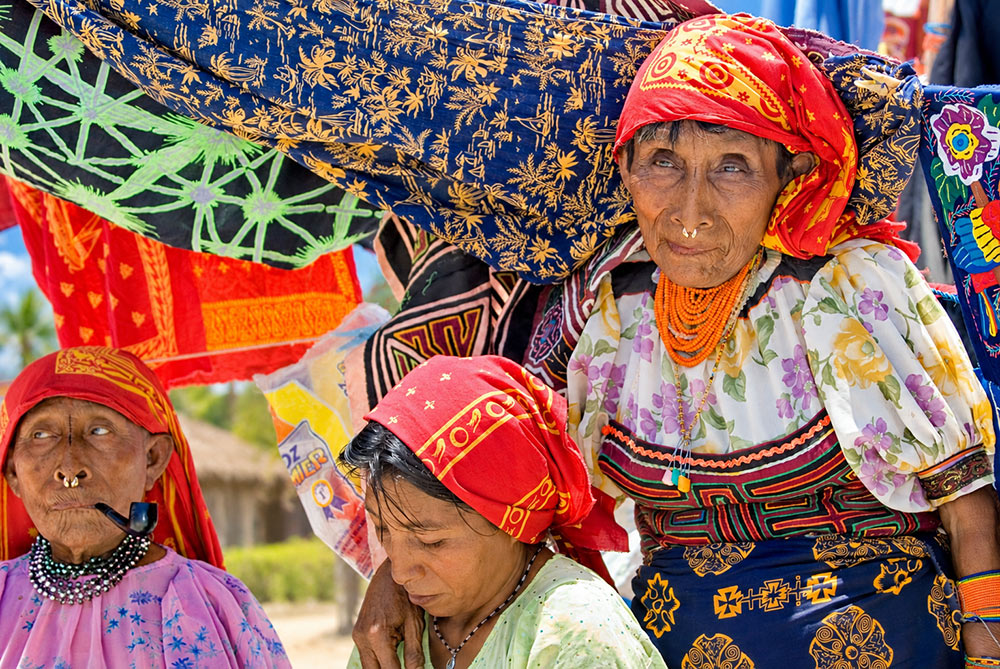 Mujeres guna con vestimenta tradicional y molas en un mercado isle&ntilde;o de San Blas