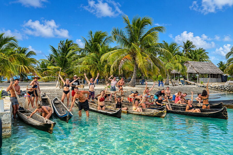 Un grupo grande de viajeros con cayucos tradicionales en una isla de San Blas
