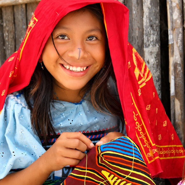 Ni&ntilde;a guna cosiendo una mola tradicional en su comunidad